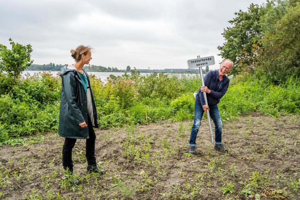 Voorzitter Ed Krijgsman ontvangt Corona-proof het bord van Gedeputeerde Anne Koning